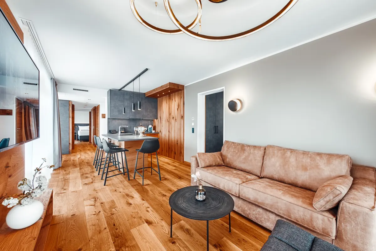 Suite mit Ledersofa, Holzboden und offener Küche