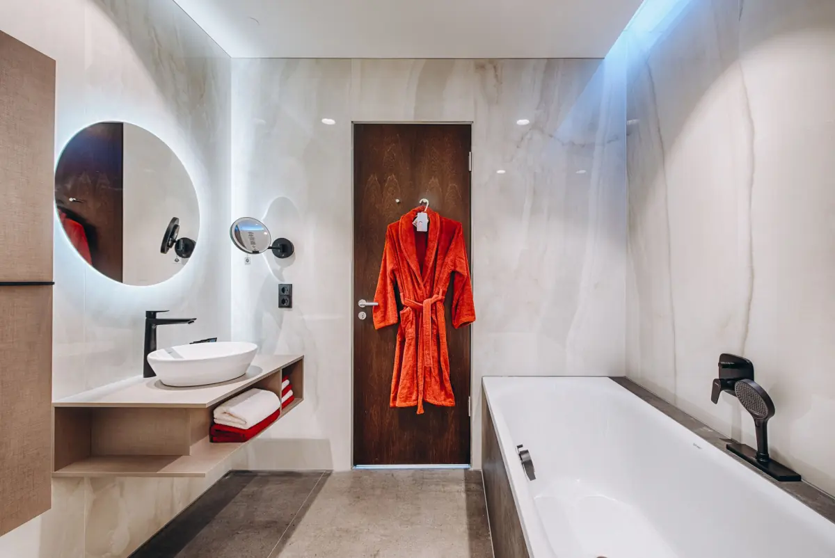Bad mit freistehender Wanne und rotem Bademantel