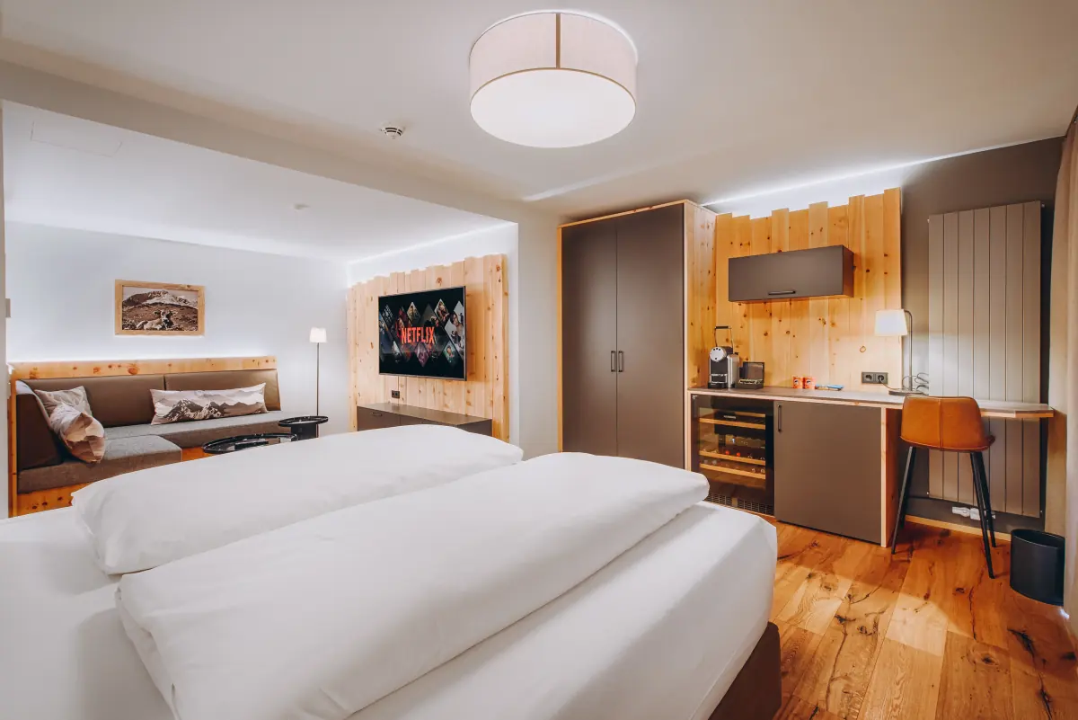 Zimmer mit Sitzecke, Holzschrank und Doppelbett