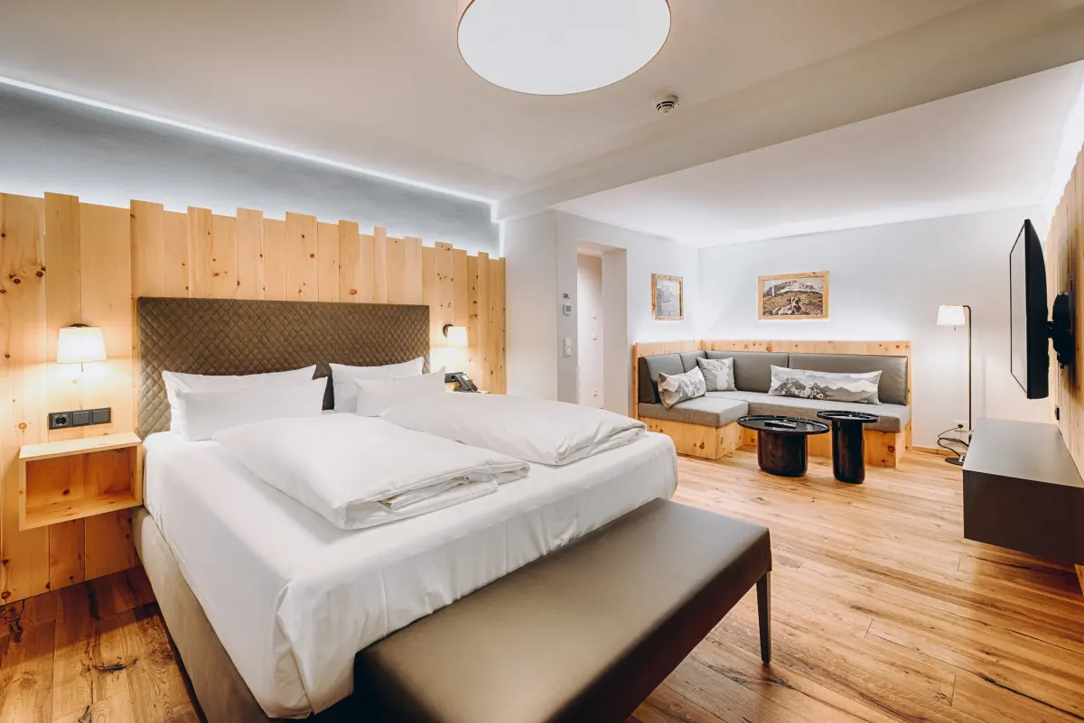 Doppelzimmer mit Holzkopfteil und Sitzecke