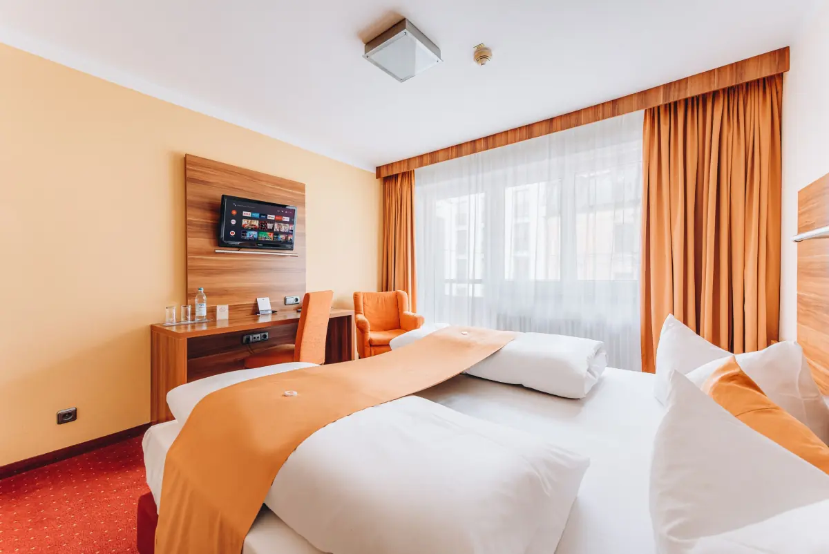 Doppelzimmer mit orangefarbenen Akzenten