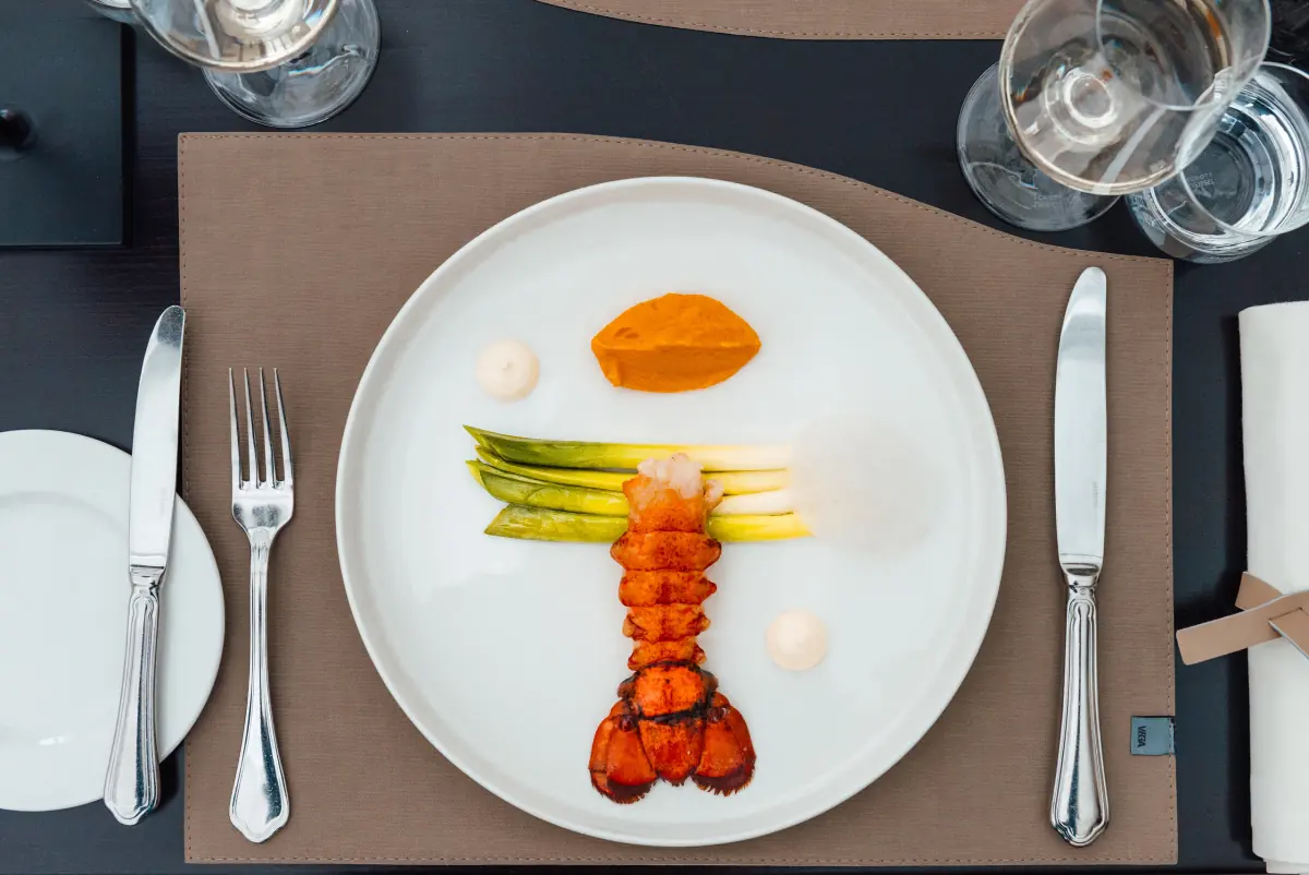 Hummer mit grünem Spargel auf weißem Teller