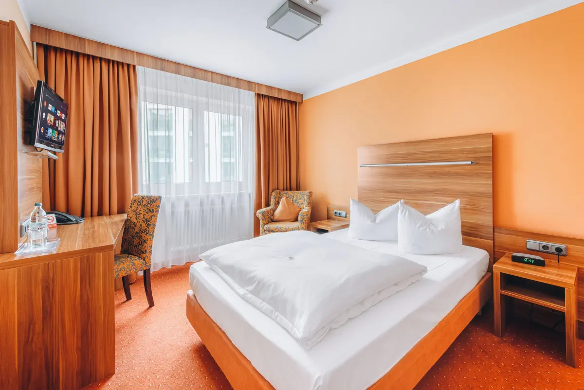 Zimmer mit orangefarbener Wand und Holzkopfteil