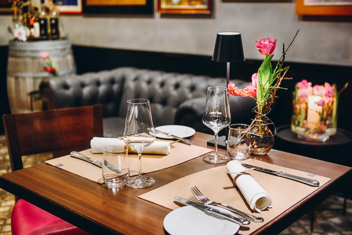Gedeckter Tisch mit Tulpen vor dem Chesterfield-Sofa