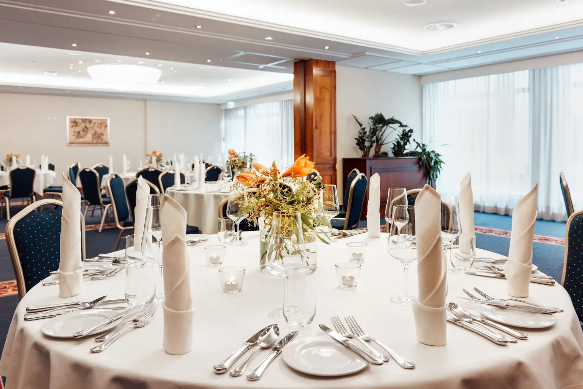 Festlich gedeckte runde Tafel mit Blumen