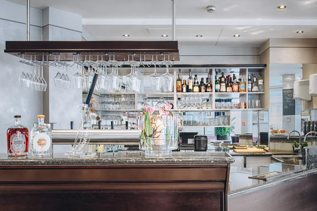 Bar mit Gläsern und beleuchtetem Flaschenregal
