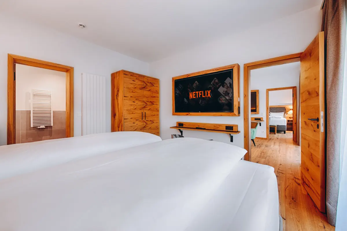 Doppelzimmer mit Holztüren und Blick ins Bad
