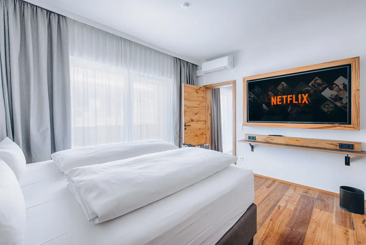 Doppelzimmer mit großem Fenster und Holzmöbeln