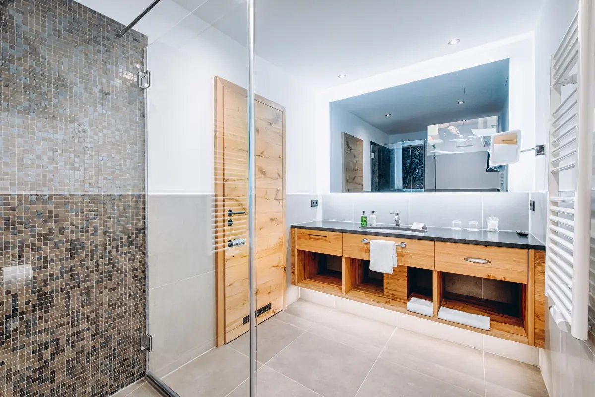 Bad mit Mosaikwand und eingebautem Holzwaschtisch