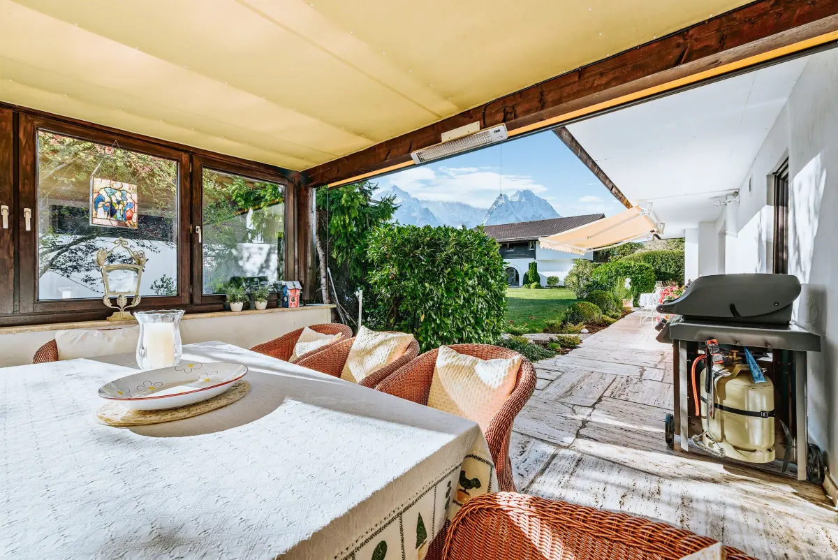 Überdachte Terrasse mit Holztisch und Bergblick