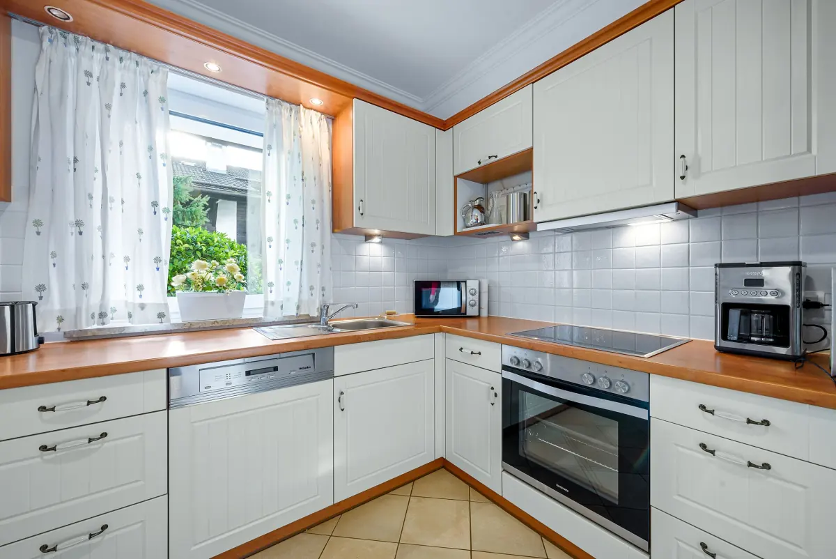 Weiße Landhausküche mit Einbaugeräten