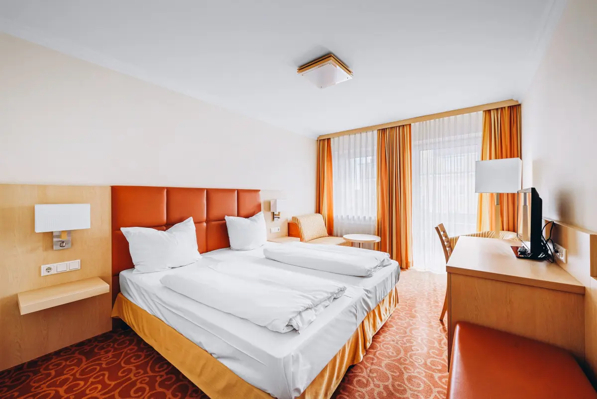 Doppelzimmer mit orangefarbenem Kopfteil