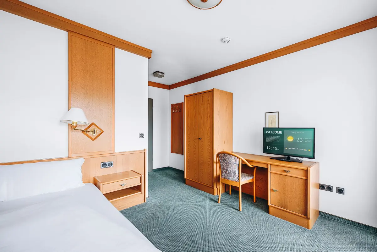 Zimmer mit Holzmöbeln und grünem Teppich
