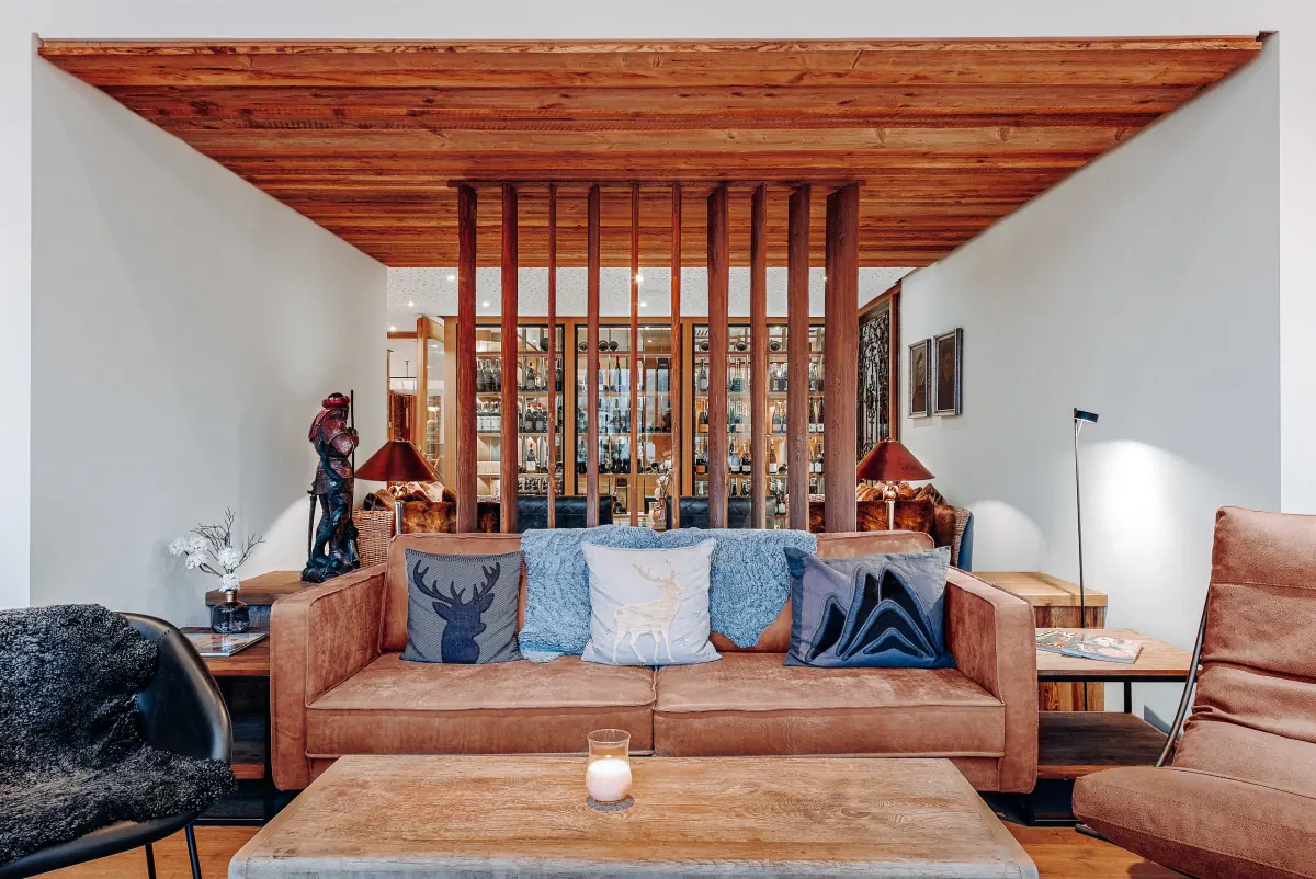 Lounge mit Ledersofa, Kerzenlicht und warmem Holz