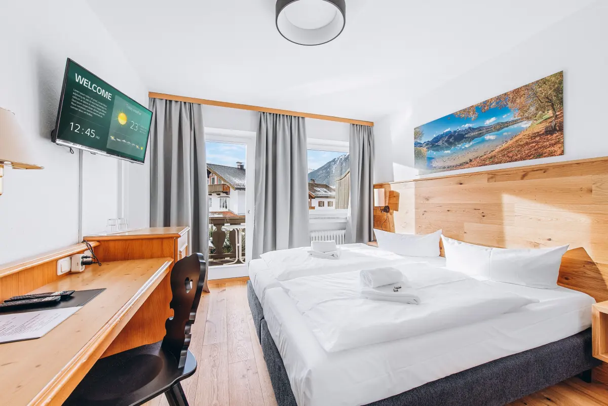 Doppelzimmer mit Holzschreibtisch und Bergblick