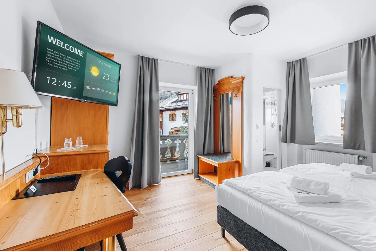 Zimmer mit Holzschreibtisch und Doppelbett