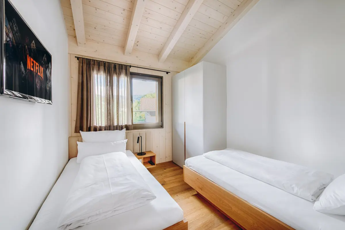 Helles Zimmer mit Holzboden und großen Fenstern