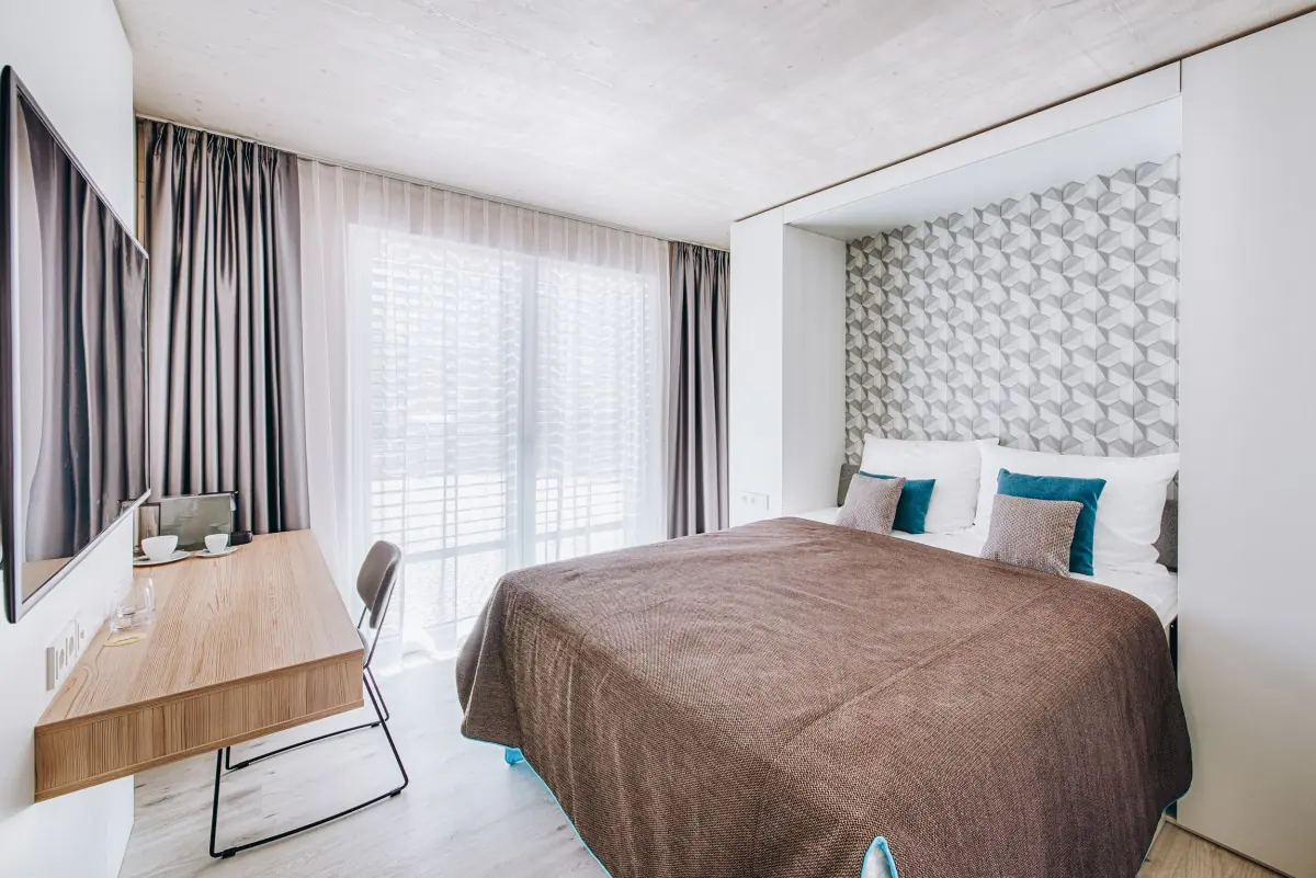 Zimmer mit braunem Bett und geometrischem Kopfteil