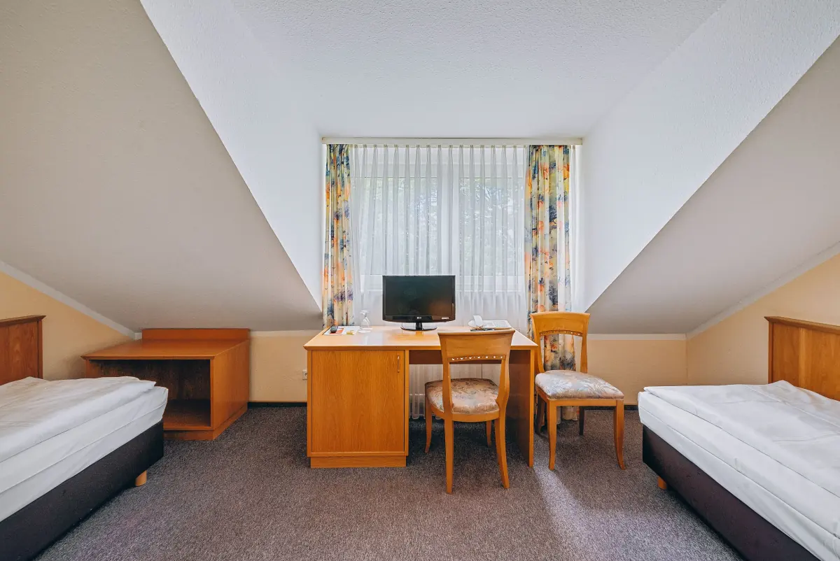 Zweibettzimmer mit Dachschräge und Schreibtisch