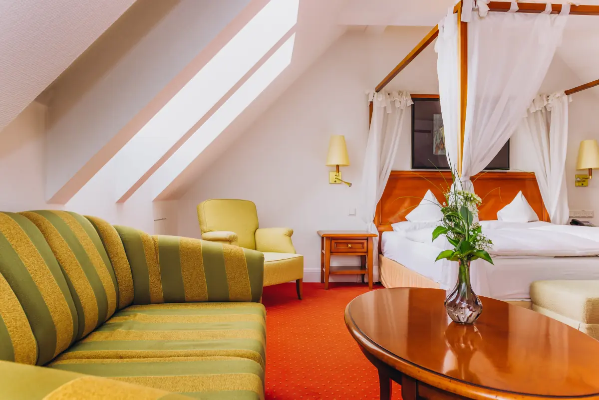 Suite mit Himmelbett, Sofa und rundem Tisch