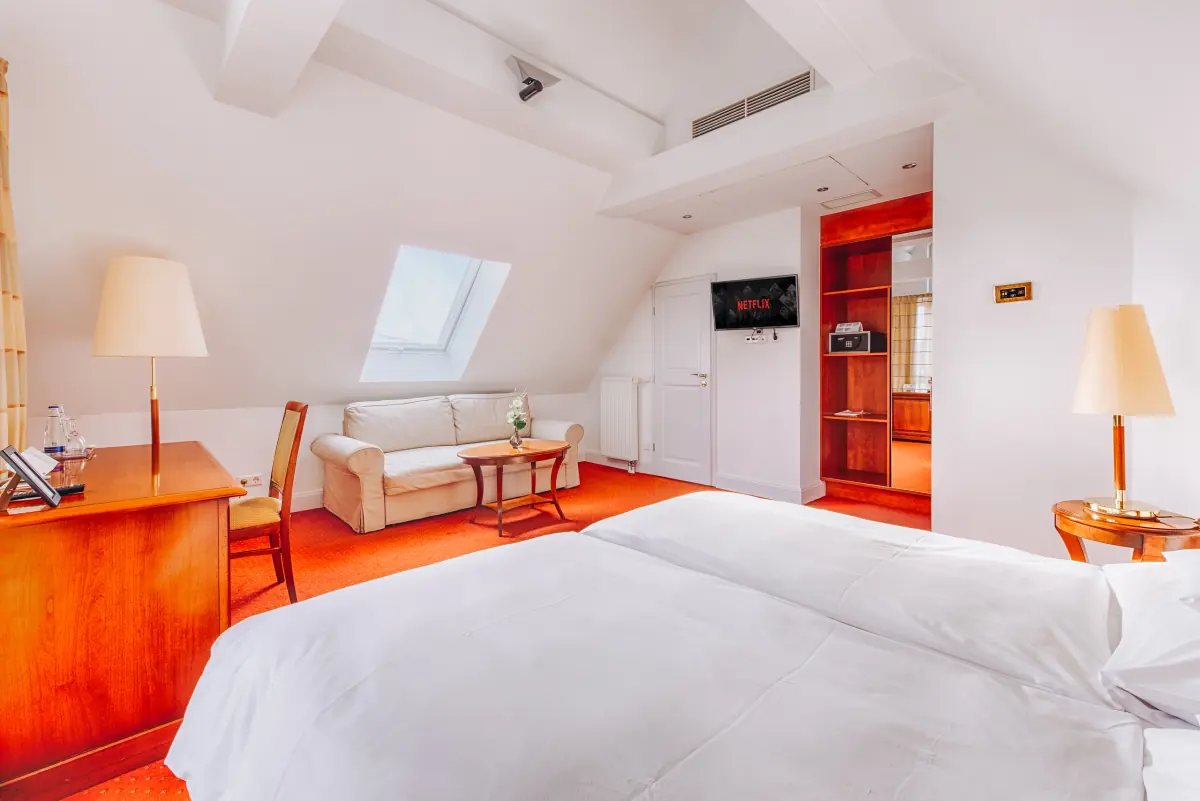 Helles Dachzimmer mit Schreibtisch und Leselampen