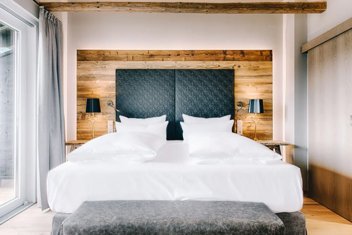 Doppelzimmer mit Altholzwand und gestepptem Kopfteil